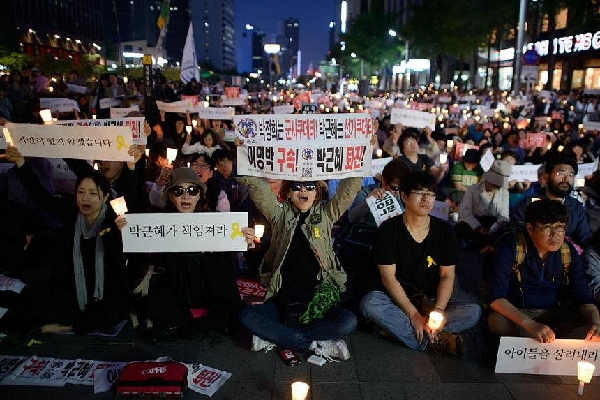 People shout slogans as they hold placards reading 'Your fault, President' and 'down with friends of Lee Myung Bak' during a rally paying tribute to victims of the Sewol ferry disaster in Seoul on May 10, 2014. -- FILE PHOTO: AFP