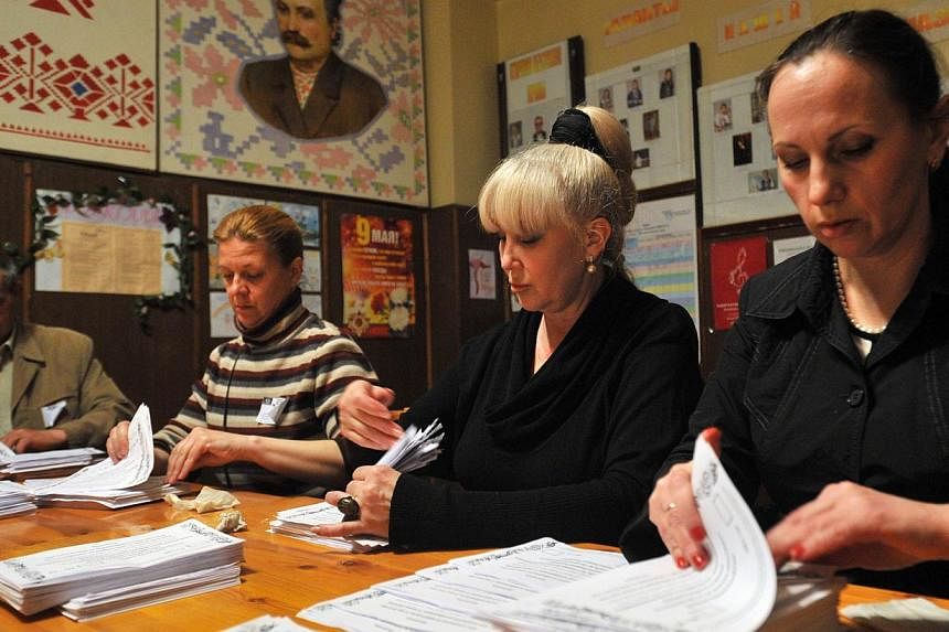 Members of an election commission count ballot papers at a polling station in the eastern Ukrainian city of Donetsk on May 11, 2014. -- PHOTO: AFP &nbsp;