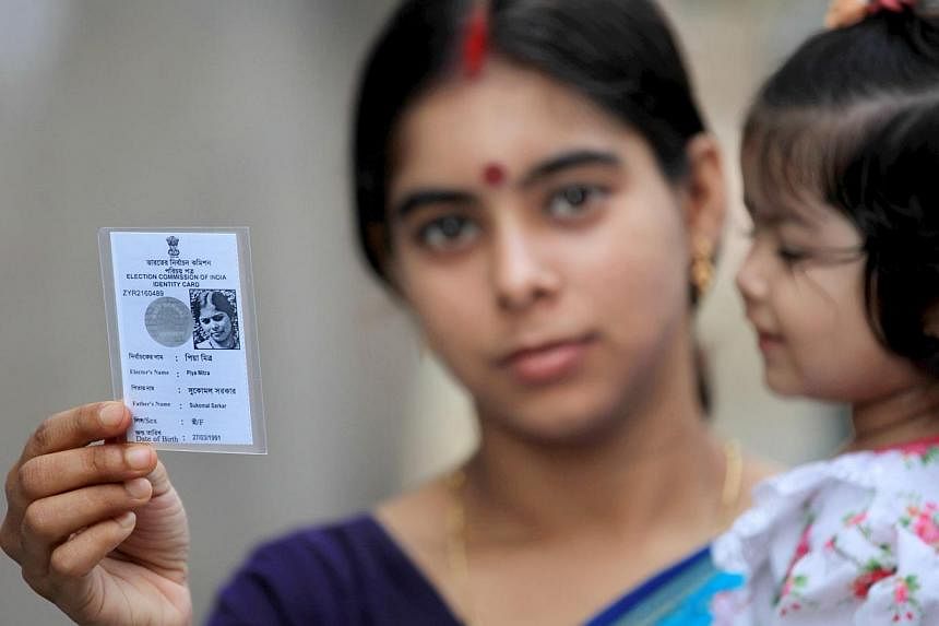 An Indian voter shows her voter card near a polling station during the ninth and final phase of the parliamentary elections in Kolkata, India, 12 May 2014. A total of 814.6 million voters voted in the parliamentary elections between 7 April and 12 Ma