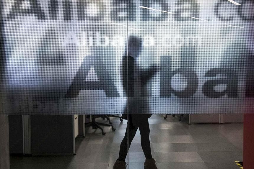 An employee is seen behind a glass wall with the logo of Alibaba at the company's headquarters on the outskirts of Hangzhou, Zhejiang province, April 23, 2014.&nbsp;Mr Jack Ma, the founder and executive chair of Alibaba Group Holding, said investors 
