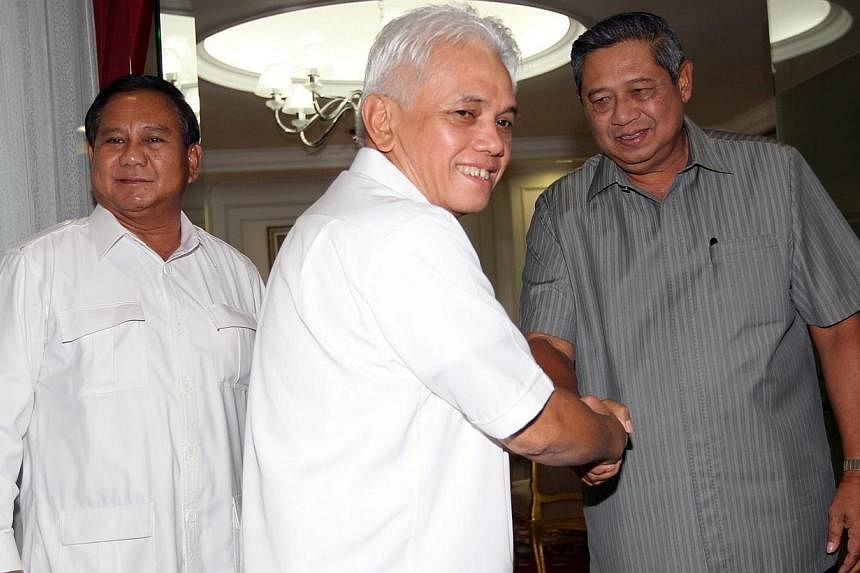 National Mandate Party chairman Hatta Rajasa (centre) shakes hand with Indonesian President Susilo Bambang Yudhoyono (right) accompanied by an Indonesian president candidate and head of the Great Indonesia Movement Party (Gerindra) Prabowo Subianto (