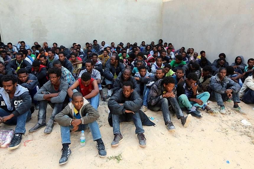 Some of the 340 illegal migrants who were rescued by the Libyan navy off the coast of the western town of Sabratha when their boat began to take on water, sit at a shelter on May 12, 2014 in the coastal town of Zawiya, west of Tripoli.&nbsp;At least 