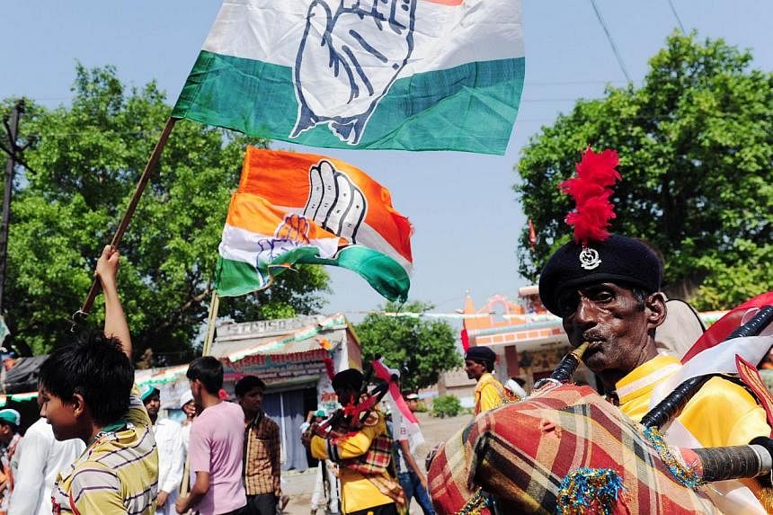 Congress Party members wave flags at a recent rally. The party, which is facing defeat nationwide, has got a face-saving support in two southern Indian states. --PHOTO: AFP