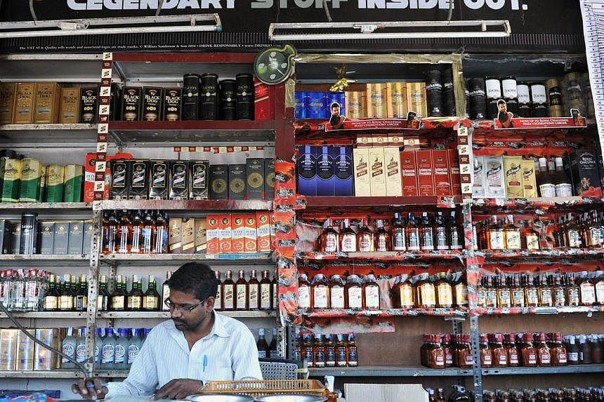 A file photograph of an Indian employee stocking alcohol at a store in Hyderabad. Influencing voters through illicit liquor and cash is an age-old trick across the country, despite heavy penalties prescribed by the Election Commission against vote-bu