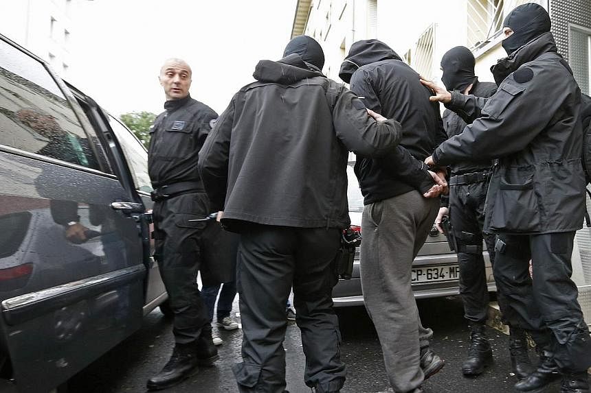 French special Police forces escort a suspect from a residential building in the Meinau suburb of Strasbourg, on May 13, 2014. French anti-terror police on Tuesday arrested six people suspected of going to join jihadist fighters in Syria, the interio