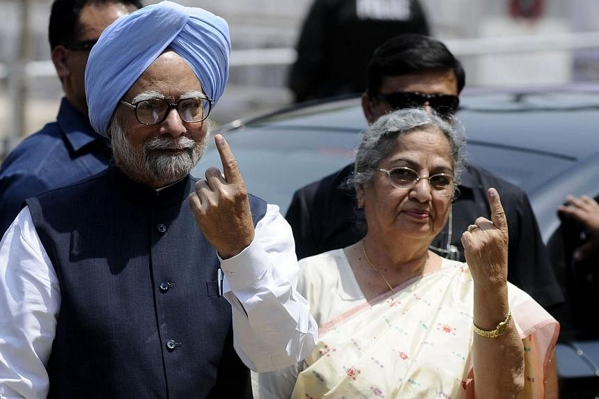 India's Prime Minister Manmohan Singh and his wife Gursharan Kaur show their ink-stained fingers after casting their votes at a polling station during the sixth phase of India's general election in the northeastern Indian city of Guwahati. Saturday w