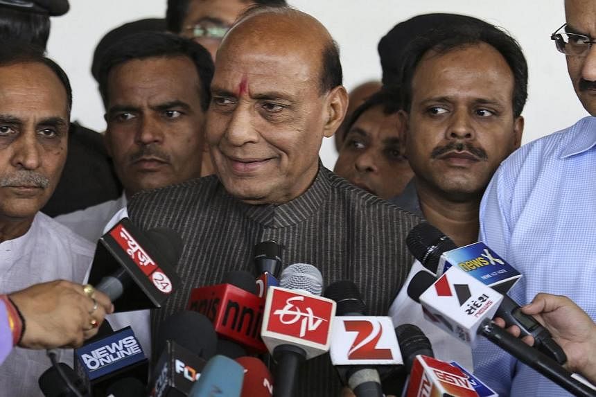 Bharatiya Janata Party (BJP) President Rajnath Singh (C) speaks to the media in Ahmedabad where he met with party prime ministerial candidate and Gujarat Chief Minister Narendra Modi on May14, 2014. Party bigwigs held a meeting allegedly to discuss s