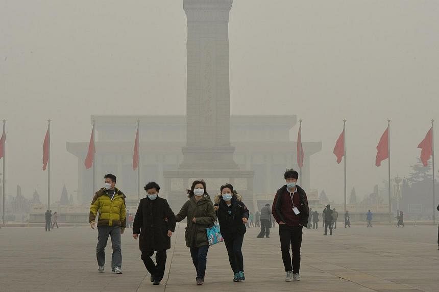 Chinese tourists wearing facemasks during a visit to Tiananmen Square as heavy air pollution continues to shroud Beijing, on&nbsp;Feb 26, 2014. Environmental inspectors in Beijing are scrambling to keep pace with a rising number of cases as the city 