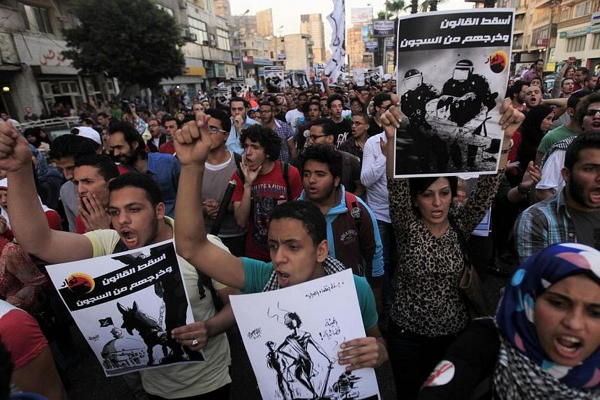 Members of the April 6 movement and liberal activists shout slogans against a law restricting demonstrations as well as the crackdown on activists, in front of El-Thadiya presidential palace in Cairo on April 26, 2014. A dissident movement which spea