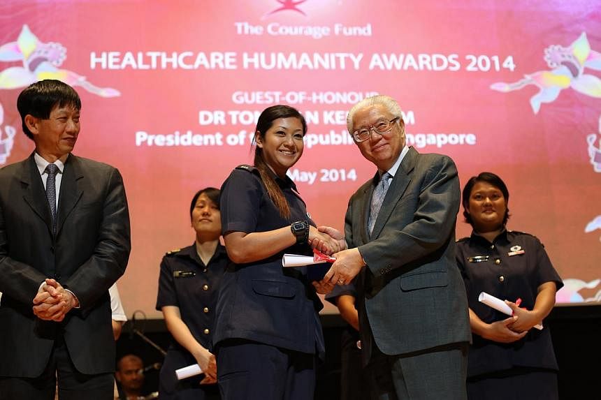 Ms Nurulelfyana Binte Badrulhisham, a paramedic, receives an Honourable Mention Award from President Tony Tan. A paramedic who conveyed the injured during the Little India riots, and a medical social worker who shielded his junior colleague and a pat