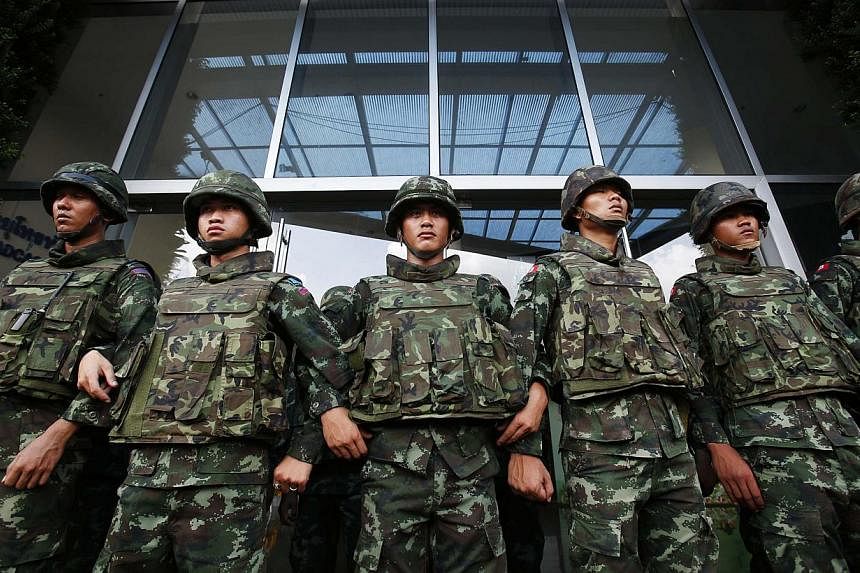 Soldiers stand guard against anti-government protesters outside the National Broadcast Services of Thailand (NBT) television station in Bangkok on May 9, 2014. The United States voiced confidence on Tuesday that Thailand’s military will not stage a