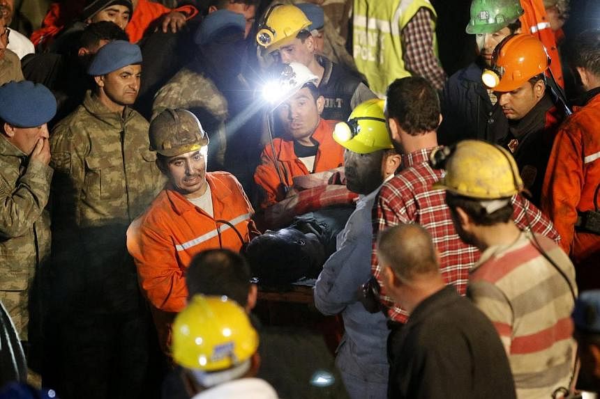 Turkish miners carry a dead miner after a mine explosion near Soma, Manisa province, Turkey, on early May 14, 2014. -- PHOTO: EPA