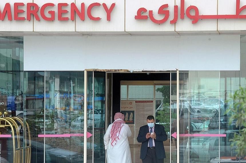 A man, wearing a mouth and nose mask, checks his phone as he leaves the hospital's emergency department on April 27, 2014 in the Saudi capital Riyadh.&nbsp;The Health Ministry will start temperature screening at air checkpoints for all passengers arr