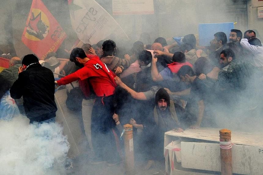 Protestors run away from tear gas during a protest on Istiklal avenue in Istanbul on May 14, 2014.&nbsp;Turkish police fired tear gas and water cannon at thousands of protesters on Thursday, as a 24-hour strike got underway over a deadly mine explosi