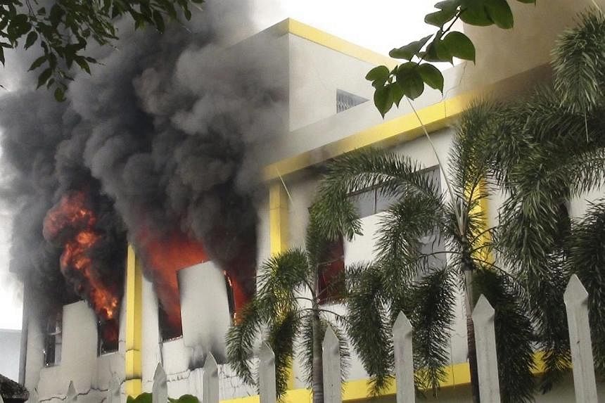 Smoke rises as a fire is seen at a Maxim company building in Binh Duong province May 14, 2014. Hundreds of Chinese nationals have fled to Cambodia to escape anti-China riots in Vietnam in which at least 20 people are reported to have been killed, Cam