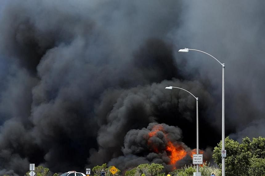 A wildfire burns through a canyon in Carlsbad, California on May 14, 2014. -- PHOTO: REUTERS