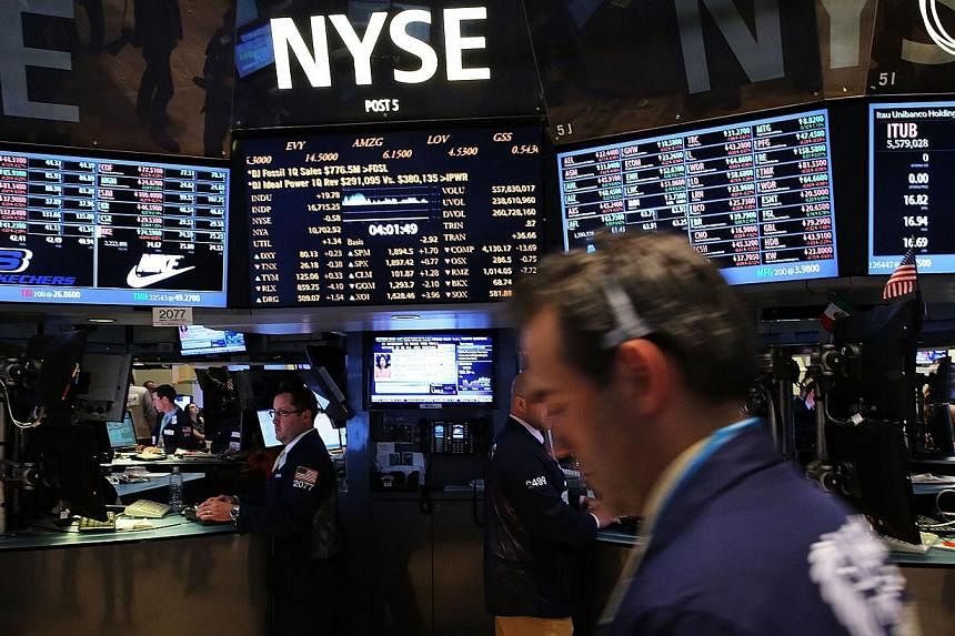 US stocks finished lower following mixed earnings and a surprising rise in producer prices, snapping a five-day winning streak for the Dow that included three straight record closings. -- PHOTO: AFP