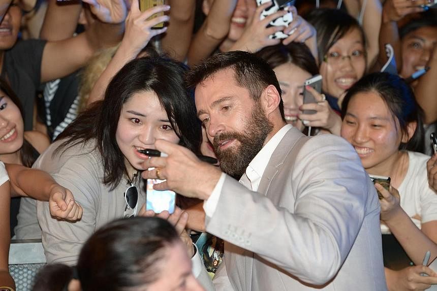 Actor Hugh Jackman snapping a selfie with a fan at the South-east Asian premiere of X-Men: Days Of Future Past, at Shaw House in Orchard Road yesterday. -- ST PHOTO: DESMOND WEE