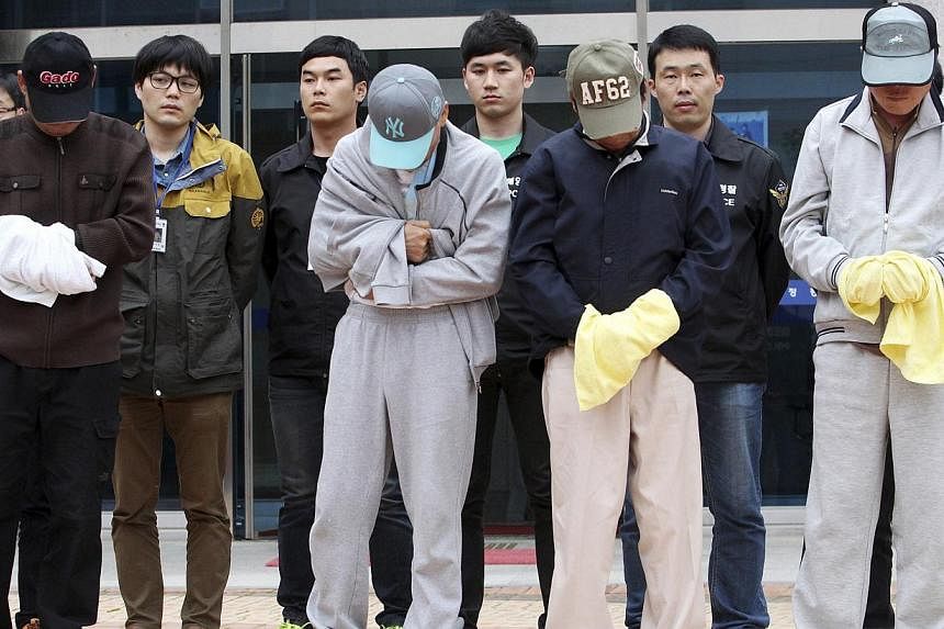 Crew members (front row) of the sunken Sewol ferry stand outside a court in Mokpo, after investigators sought for warrants of their arrest at the court on April 26, 2014. -- FILE PHOTO: REUTERS