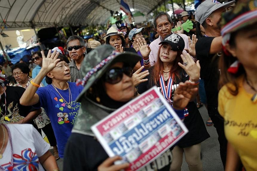 Anti-government protesters dance during a rally in an area protesters are occupying around the Government House in Bangkok on May 14, 2014.&nbsp;Two anti-government protesters were killed and 21 were wounded in a gun and grenade attack early Thursday