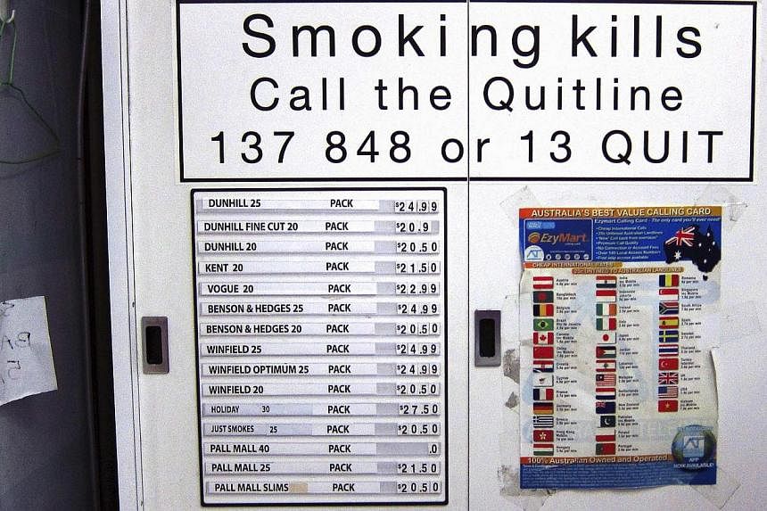 A sign to discouraging smoking is seen on a cabinet above a list displaying prices for the cigarettes inside it at a small shop in central Sydney on April 4, 2014.&nbsp;Australia has some of the toughest tobacco laws in the world, with firms forced t
