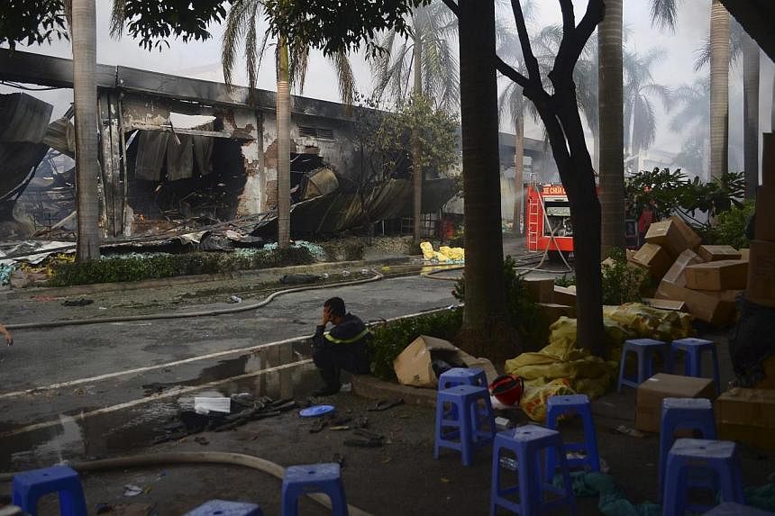 Firefighters rest near a damaged Chinese owned shoe factory in Vietnam's southern Binh Duong province on May 14, 2014.Beijing on Thursday, May 15, 2014, accused Hanoi of acting in concert with anti-China protestors who have killed at least one Chines
