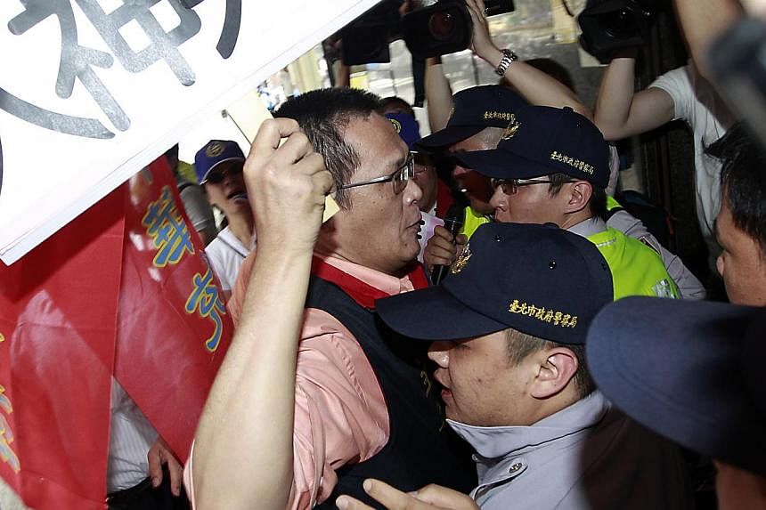 Activists holding placards scuffle with police officers during a protest in front of Vietnam Economic and Cultural office due to the anti-China protest in Vietnam, in Taipei on May 15, 2014. At least two Malaysian companies with manufacturing units i