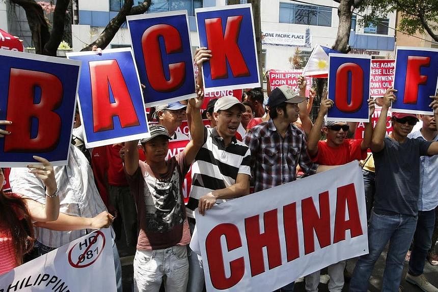 Filipino activists and Vietnamese nationals display placards and chant anti-China slogans as they march outside the Chinese Consulate in Manila's Makati financial district on May 16, 2014.&nbsp;Several hundred Filipino and Vietnamese protesters unite