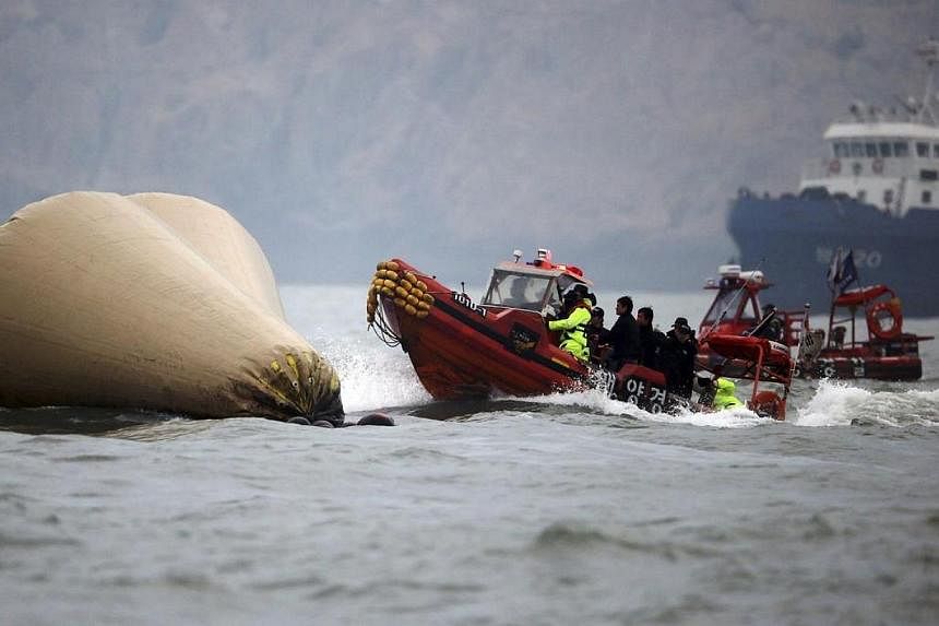 South Korean rescue workers operate near floats where the capsized passenger ship Sewol sank during a rescue and search operation in Jindo on April 27, 2014.&nbsp;South Korean prosecutors said on Friday, May 16, 2014, they were seeking a warrant for 