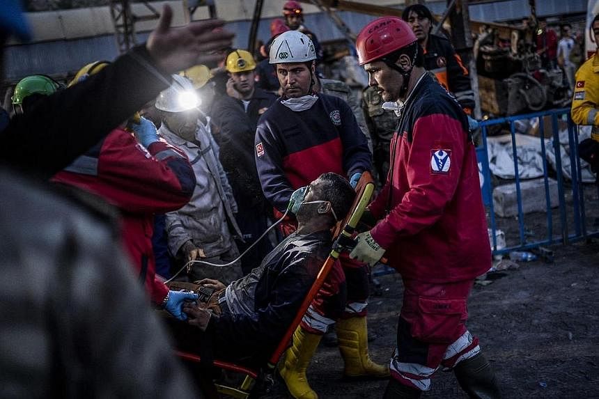 Rescuers evacuate a colleague after inhaling smoke on May 15, 2014, two days after an explosion in a coal mine at Soma in Manisa. A maximum of 18 people are still believed to be trapped in a Turkish coal mine following a blast which killed more than 