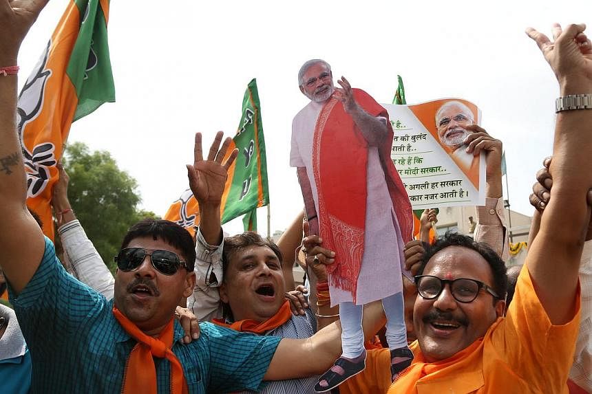 Supporters celebrate the Bharatiya Janata Party's performance in India's general election, at the party's state headquarters in Gandhinagar, the capital of Gujarat. -- PHOTO: EPA
