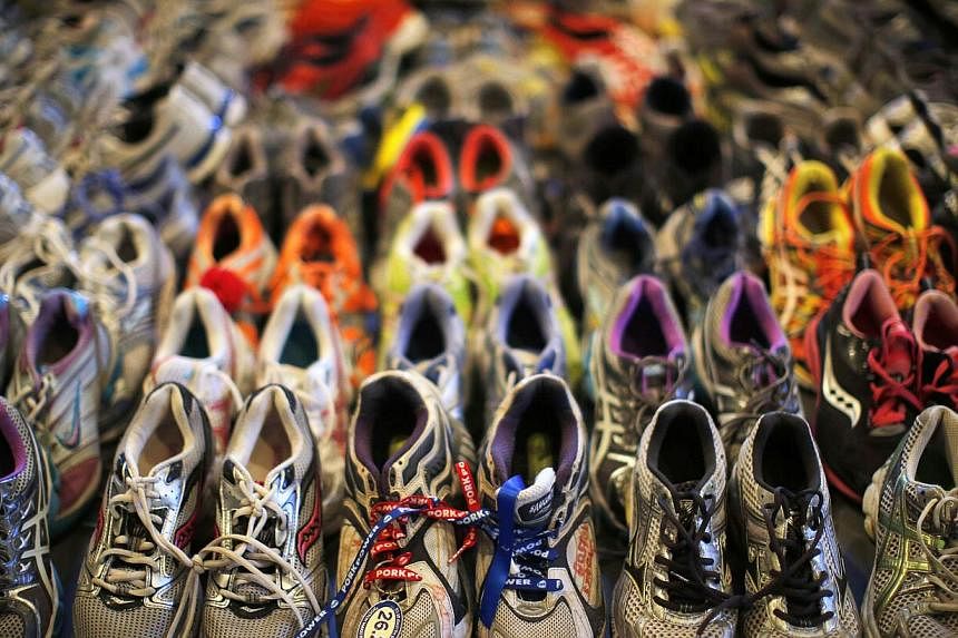 Running shoes left at a makeshift memorial for the victims of the Boston Marathon bombings are being displayed in an exhibit at the Boston Public Library.