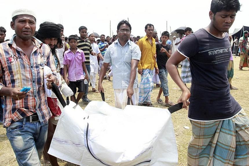 Relatives carry the body of a passenger of the capsized M.V. Miraj 4 ferry recovered from the Meghna river at Rasulpur in Munshiganj district on May 17, 2014. Anguished relatives protested a decision Saturday to stop searching for bodies of passenger