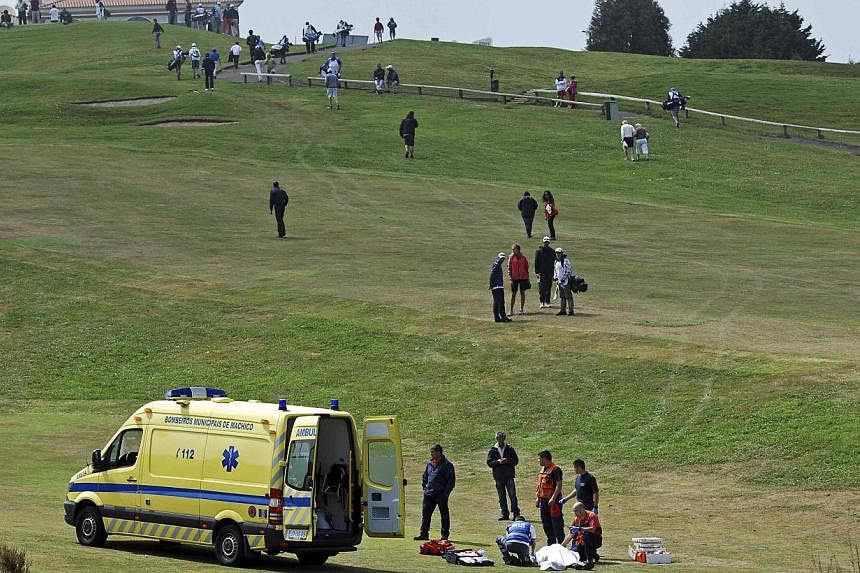 Paramedics attend to caddie Ian McGregor as he lies on the grass during the Madeira Golf Open in Santo da Serra on May 11, 2014. The European Tour has apologised to the Caddies Association for the "hurt and upset" caused following the sudden death of