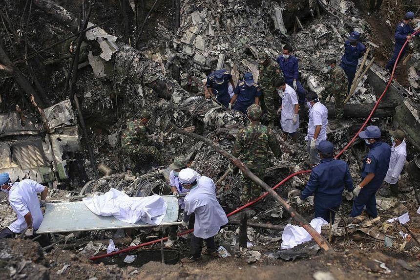 Rescue workers search an air force plane crash site near Nadee village, in Xiang Khouang province in the north of the country on May 17, 2014. A Lao military plane crashed on Saturday killing five senior officials on board including the Defence Minis