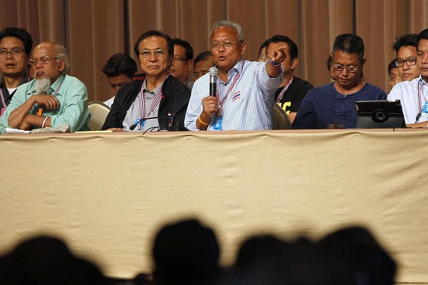 Anti-government protest leader Suthep Thaugsuban (front, third from right) speaks during a meeting with his supporters at the Government House in Bangkok on May 17, 2014. Anti-government protesters in Thailand are to stage mass rallies in coming days
