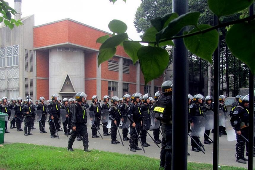 Vietnamese police officers standing guard at a Taiwanese sport shoe factory in Binh Duong as anti-China protesters set more than a dozen factories on fire in Vietnam, according to state media, in an escalating backlash against Beijing's deployment of