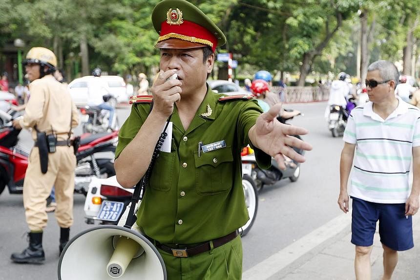 Policemen try to disperse people protesting near the Embassy of China, in Hanoi, Vietnam, on May 18, 2014. -- PHOTO: EPA