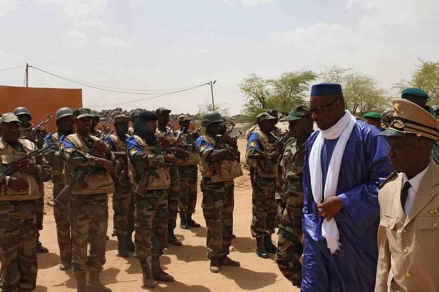 Mali's Prime minister Moussa Mara (second right) reviews troops upon his arrival at Kidal, northern Mali, on May 17, 2014, where around 30 civilians and soldiers went missing following clashes between separatist militants and the Malian army in the r