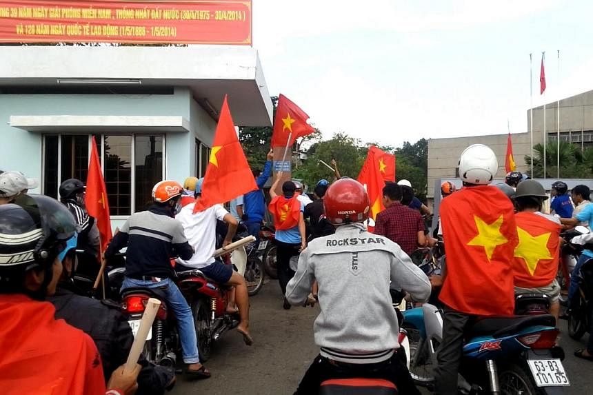 Protesters carry Vietnamese national flags as they enter a factory during an anti-China protest in Vietnam's southern Binh Duong province on May 13, 2014.&nbsp;China said Sunday it has suspended some plans for bilateral exchanges with Vietnam followi