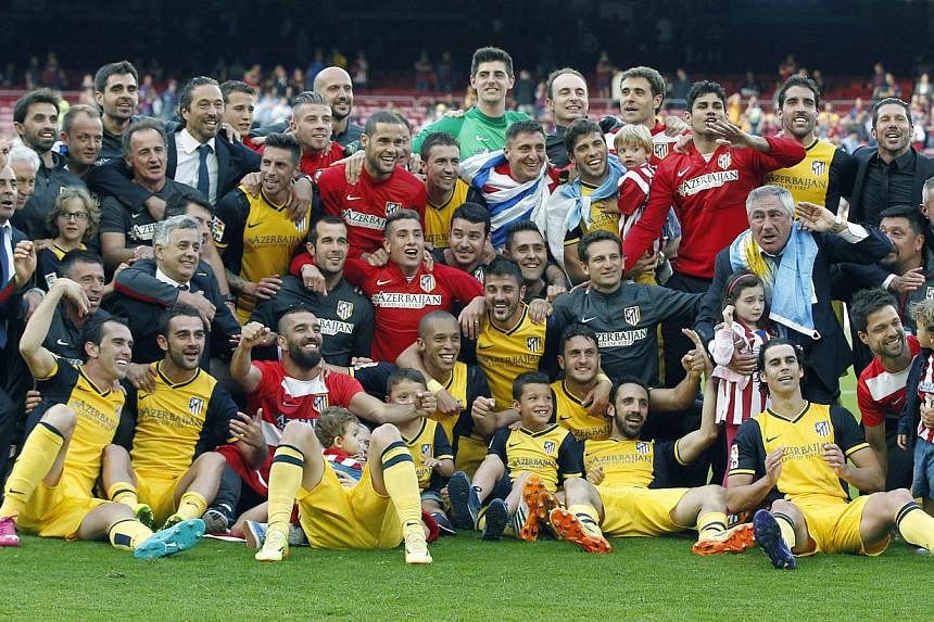 Atletico Madrid's players, coaches and managers celebrate after the Spanish Liga Primera Division soccer match between FC Barcelona and Atletico Madrid at Camp Nou stadium in Barcelona, Spain, on 17 May 2014. -- PHOTO: EPA