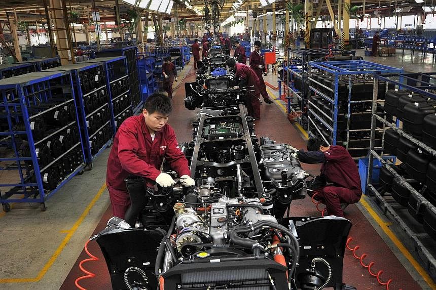 Workers install the chassis along a production line at a truck factory of Anhui Jianghuai Automobile Co. Ltd (JAC Motors) in Hefei, Anhui province on May 5, 2014. -- FILE PHOTO: REUTERS