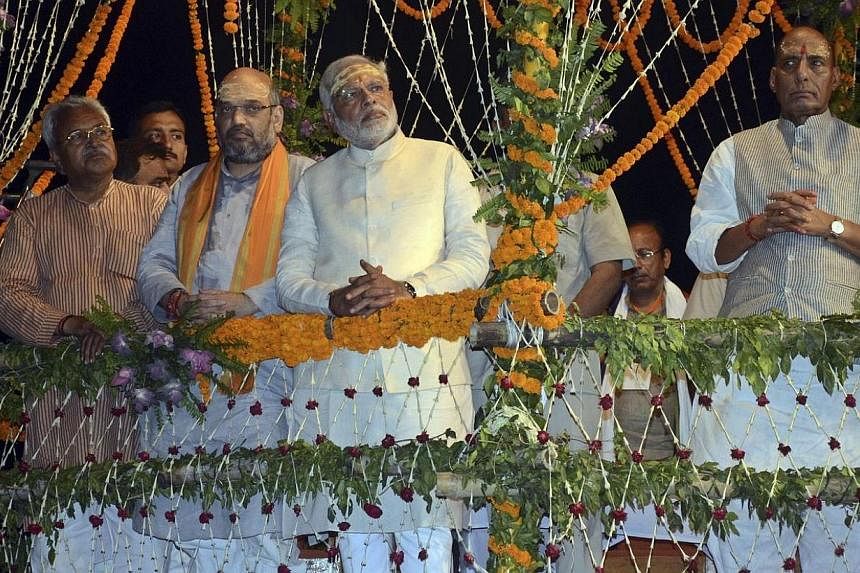 Hindu nationalist Narendra Modi (centre), India's prime minister-elect from the Bharatiya Janata Party (BJP), watches a ritual known as "Aarti" during evening prayers on the banks of river Ganges at Varanasi, in the northern Indian state of Uttar Pra