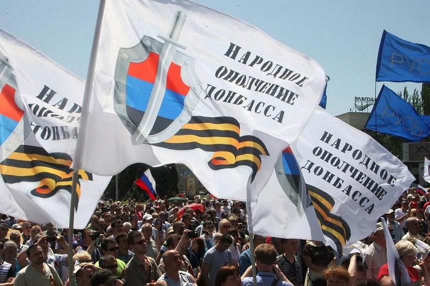 People wave flags bearing the emblem of the so-called "People's Republic of Donetsk" during a rally of pro-Russian separatists in the eastern Ukrainian city of Donetsk on May 18, 2014.&nbsp;Rebel leaders in eastern Ukraine launched a desperate appeal