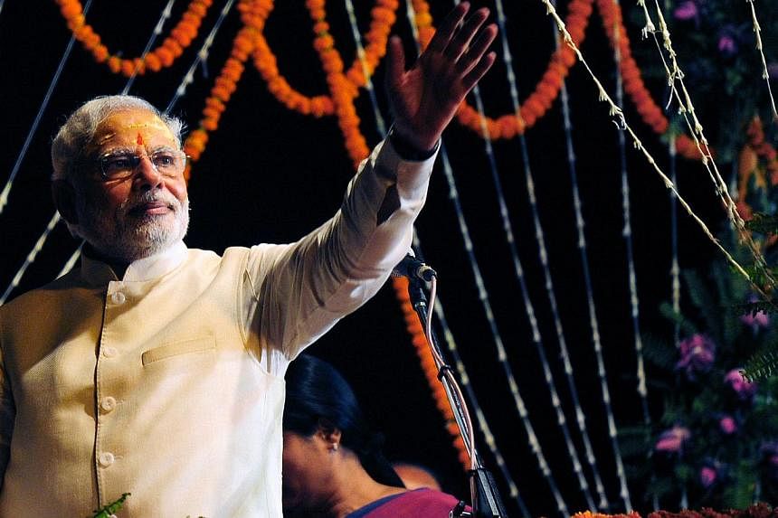 Indian prime minister-elect Narendra Modi waves to supporters after performing a religious ritual at the banks of the River Ganges in Varanasi on May 17, 2014. -- PHOTO: AFP