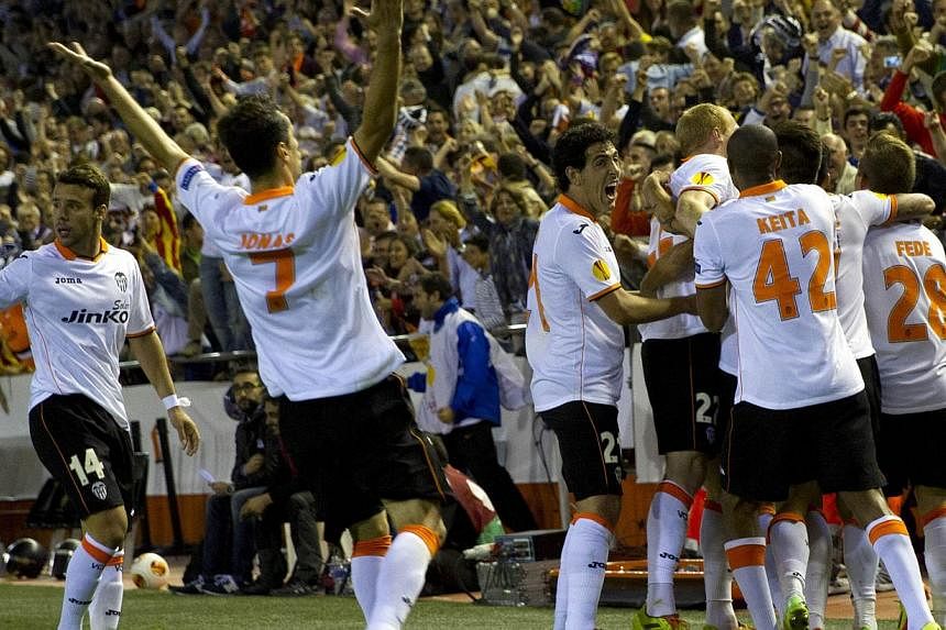 Valencia's players celebrate after scoring their third goal during the UEFA Europa League semi-final second leg football match Valencia CF vs FC Sevilla at the Mestalla stadium in Valencia on May 1, 2014. -- FILE PHOTO: AFP