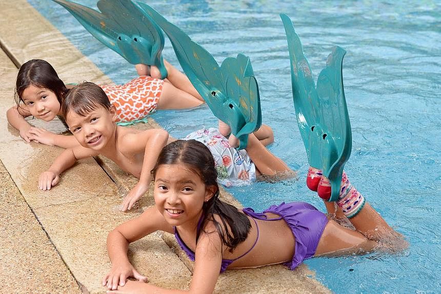 MerFins give (from Left) Lucy Meyer, five, and her friends Stan Rowe, five, and Zoe Rowe, seven, the thrill of pretending they are mermaids.
