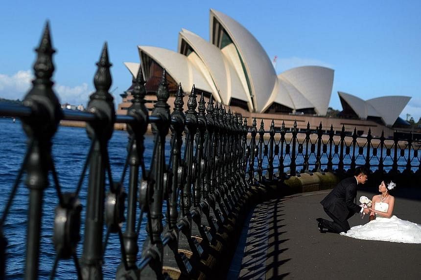 A couple posing for their wedding photo in front of Sydney's iconic Opera House last week. Along with much of south-eastern Australia, the capital of New South Wales is in the midst of an autumn heatwave that is setting records, with daily maximum te