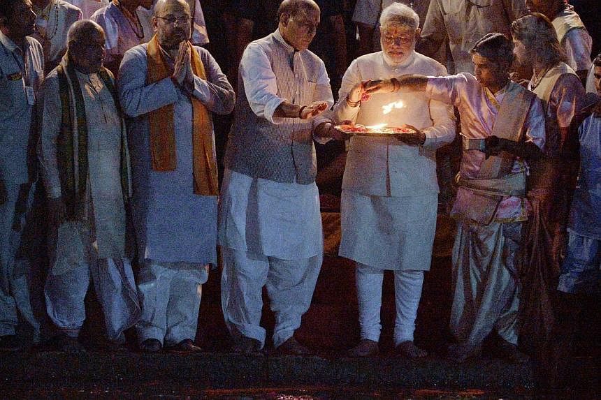 Indian prime minister-elect Narendra Modi, who is holding a tray, performs a religious ritual at the banks of the River Ganges in Varanasi on May 17, 2014. He&nbsp;vows to clean up the holy river Ganges, sacred to millions of Hindus but seeped in fil