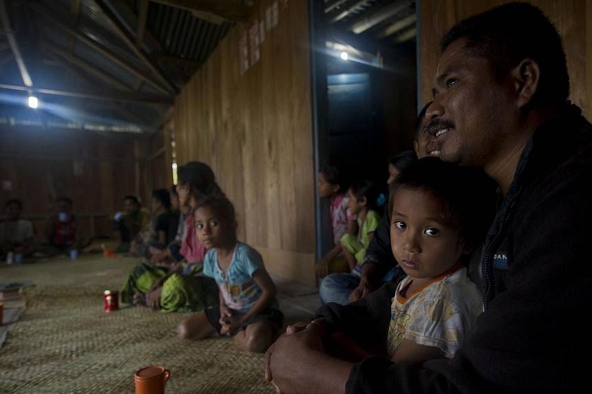 Sumbanese family gather in their house installed with electricity generated from field of small wind turbine in Kamanggih village in Sumba island located in central Indonesia. Until two years ago, most people in Kamanggih village had no power at all,